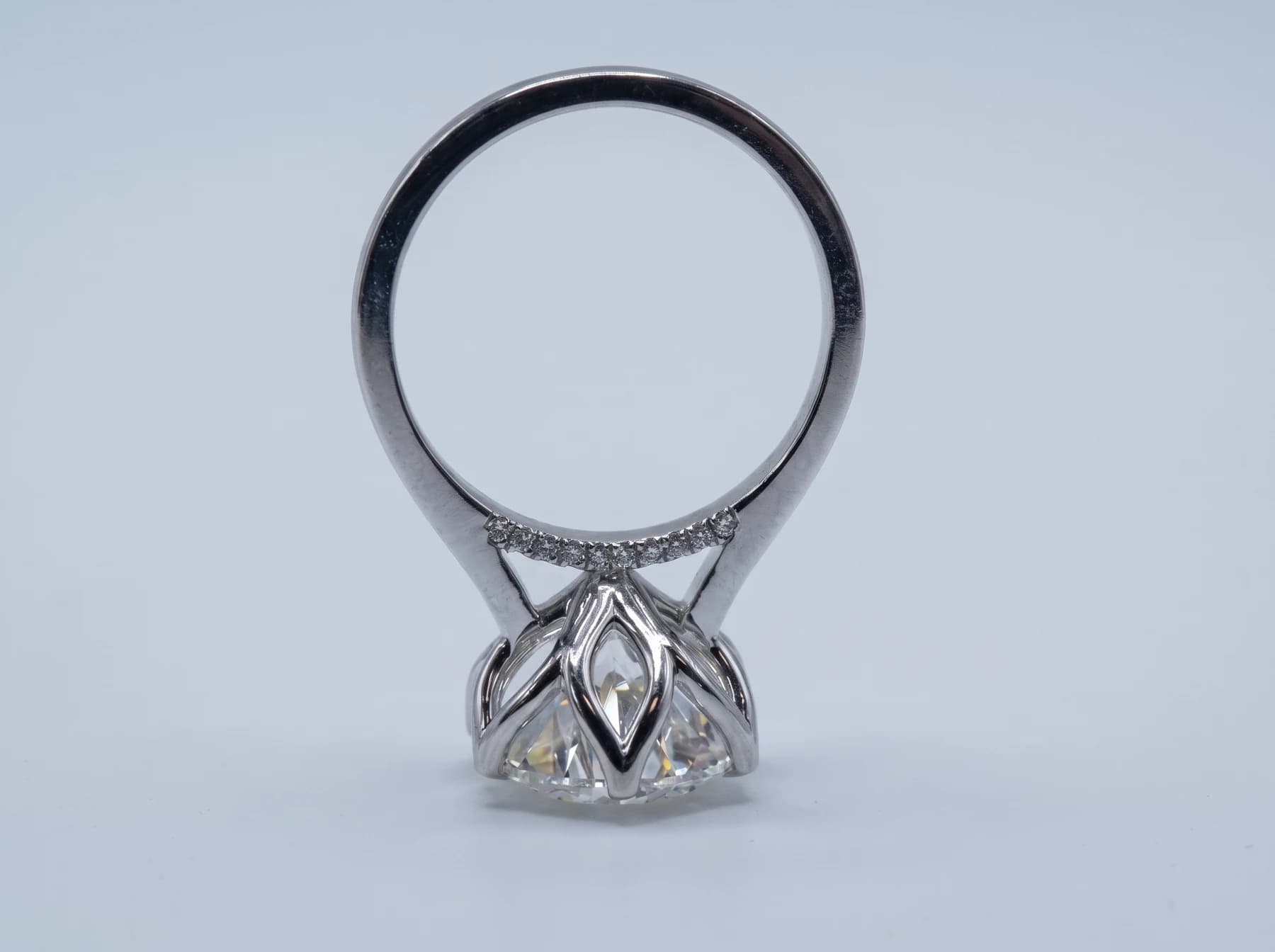 Underside of a ring showing the stone’s pavilion, open setting and small accent stones